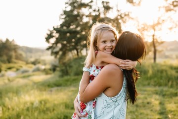 Stylish mother and handsome daughter having fun on the nature. Happy family concept. Beauty nature scene with family outdoor lifestyle. family resting together. Happiness in family life. Mothers day