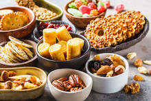 Variety Of Snacks And Sweets On Gray Background. Waffles, Nuts, Sweets, Cookies, Chips And Fruits.