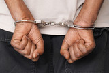 Fototapeta  - Close-up arrested hands african man handcuffed. Prisoner or arrested terrorist hands in handcuffs. 