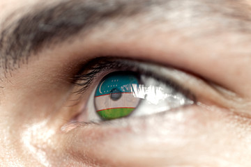 Flag of uzbekistan reflects in a man brown eye - election, sport, hope, young, generation	