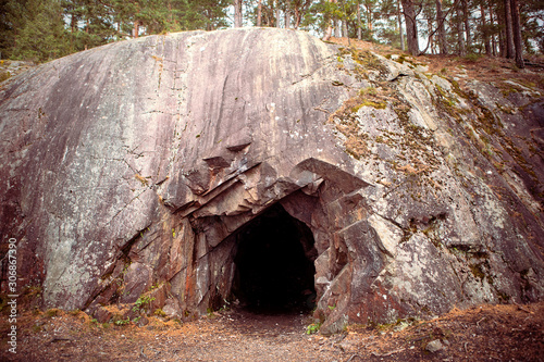 Fotomural Black hole in rock wall, entrance to the cave in Spro, old mineral mine