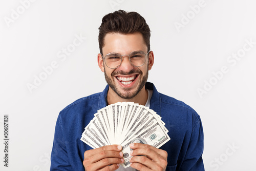 Cuadros en Lienzo Attractive man is holding cash money in one hand, on isolated white background