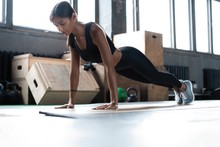 Woman Doing Planks On Gym Floor. Healthy Lifestyle Concept