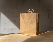 Disposable Bag Of Kraft Paper On A Wooden Table.
