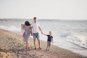 Happy family having fun near sea at the beach.