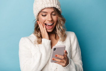 Wall Mural - Portrait of cute surprised woman smiling and using cellphone