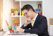 © alexzeer - Casual businessman working in office, sitting at desk, typing on keyboard, looking at computer screen.?