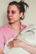 Portrait of a crying young mother holding her baby on white background. Concept of postpartum depression