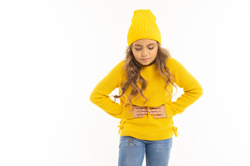 Wall Mural - European attractive girl in yellow hat holds on to a stomach on a white background