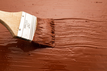 Wall Mural - Paint brush. Man paints the boards with brown paint.