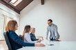 © bnenin - Friendly leader giving briefing to company executives in the boardroom office.