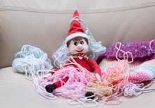 Christmas Elf Mischief, Naughty Elf Makes Mess With Knitting Wool. Typical Bad Behaviour From Toy Elf
