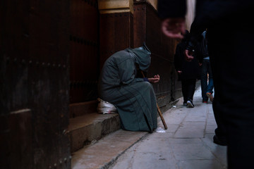 a poor beggar man in traditional moroccan hoody djellaba outfit. fokiya, jellaba. anonymous poor beg