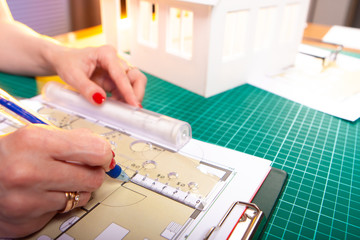 Poster - the architect draws a plan of future apartments. hands, ruler and drawing. the girl draws the bounda