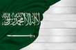 horizontal colored national flag of modern state of Saudi Arabia, beautiful silk, white wood background, concept of tourism, economy, politics, emigration, independence day, copy space, template