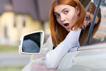 Young Woman Driving A Car Backwards. Girl With Funny Expression On Her Face While She Made A Fender Bender Damage To A Rear Vehicle.