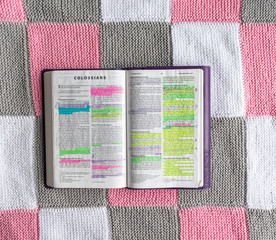 Wall Mural - Open Bible flat lay on white, grey and pink background 