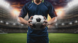 Fototapeta Sport - The concept of playing football.soccer player with Football on soccer field.