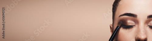 Fotomural Process of applying brown eyeshadow on young woman eyes