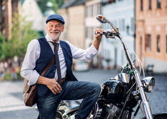 Wall Mural - A senior businessman with motorbike in town.