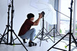 Young photographer adjust light in modern studio background