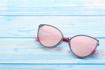 Canvas Print - Modern sunglasses on blue wooden table