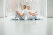 © HBS - Shot of two senior people doing yoga in the class. Fitness people sitting on the exercise mat and relaxing in yoga position. Group of people meditating in lotus pose in yoga class.