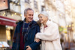 © pikselstock - Senior couple walking on the city street at winter day