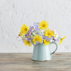 spring flowers in vintage jug on wooden table