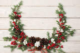 Fototapeta Nowy Jork - Christmas wreath on white wooden backdrop