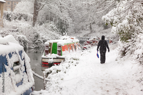 Fotomural Woman walking in heavy snow on the Kennet and Avon towpath in Bath, England, UJK