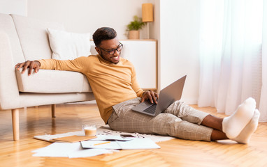 Aufkleber - Happy afro entrepreneur working on laptop sitting on floor indoor