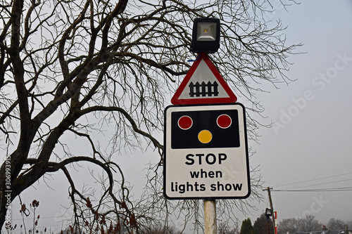 Sign for railway level crossing taken in Corpach near Fort William, Scotland. Sign asks vehicles and people to stop when lights show.