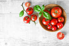 Fresh Red Variety Tomatoes With Basil On White Rustic Table. Tomato Vegetable Concept Space For Text Or Banner Top View.