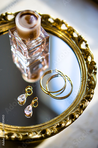 Cuadros en Lienzo Golden earrings with gemstones and perfume on mirror tray