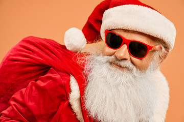 Wall Mural - Portrait of cool Santa Claus wearing trendy sunglasses