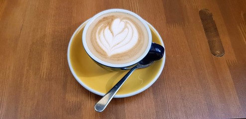 Two cup of capuccino coffees on a wooden table