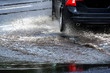 Car and water splash after rain on road