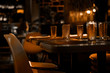 Cozy interior of restaurant or cafe with soft warm light of lamps in evening. Elegantly served tables with faceted glasses. Beautiful place for dinner, celebration, romantic date and meeting friends.