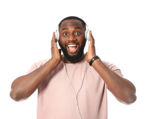 Wall Mural - Emotional African-American man listening to music on white background