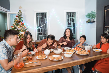 Wall Mural - portrait of indonesian family having christmas eve dinner together at home