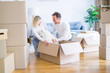 © Krakenimages.com - Young beautiful couple with dog sitting on the floor at new home around cardboard boxes
