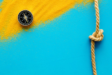 Wall Mural - Goal achievement concept. Compass near rope with knot on blue background top view copy space
