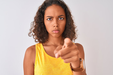 Wall Mural - Young brazilian woman wearing t-shirt standing over isolated white background pointing with finger to the camera and to you, hand sign, positive and confident gesture from the front