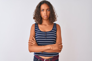 Wall Mural - Young brazilian woman wearing striped t-shirt standing over isolated white background skeptic and nervous, disapproving expression on face with crossed arms. Negative person.