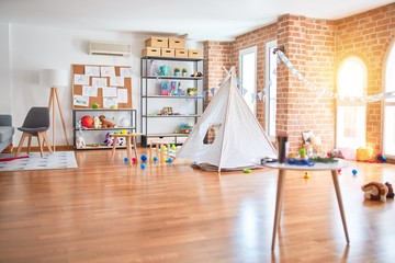 Picture of preschool playroom with colorful furniture, and toys around empty kindergarten