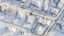 Top View Of The Winter Village With Snow Covered Houses And Roads. Aerial View Of Landscape