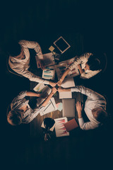 Sticker - High angle above view vertical photo of four people business partners sitting table working late night holding arms pile stack union one team soul formalwear lamp light indoors