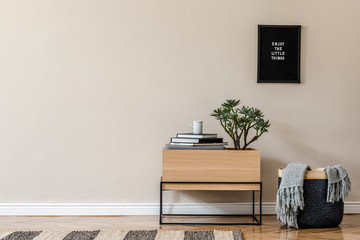 Interior design of living room at scandinavian apartment with stylish commode, tropical plants, books, tea pot and elegant accessories. Modern home decor. Template. Copy space. Beige walls.