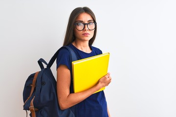 Wall Mural - Young student woman wearing backpack glasses holding book over isolated white background with a confident expression on smart face thinking serious